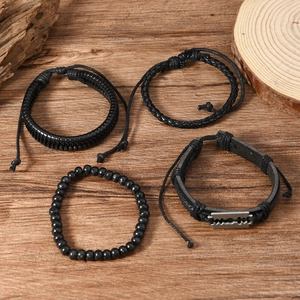 Men's 4-piece set of black braided leather bracelets with alloy blade charm on wood background