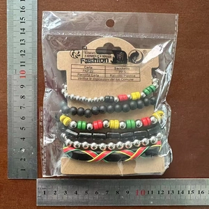 Set of five bohemian beaded bracelets in red, yellow, green and silver tones on wood