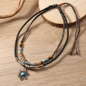 Detail of bohemian layered necklace with turquoise beads and vintage floral pendant