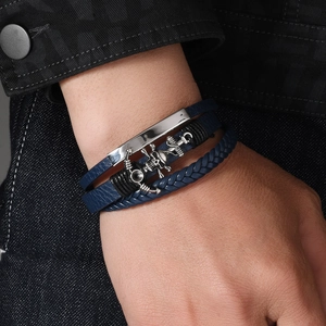 Detail of navy blue leather layered punk bracelet with silver skull anchor and metal plate