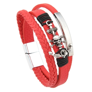 Detail of red multilayer leather bracelet with silver pirate anchor and skull pendant