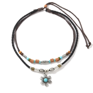 Detail of bohemian layered necklace featuring turquoise stones and vintage silver pendants