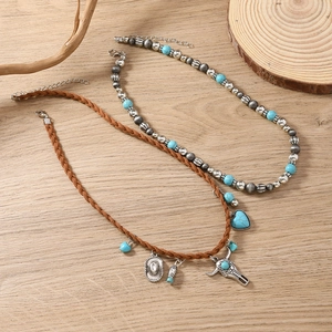 Bohemian turquoise beaded necklace set with vintage bull head and heart charms on wood