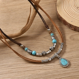 Macro detail of bohemian double-layer necklace with turquoise beads and vintage silver accents