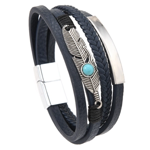 Macro view of multi-layer blue leather bracelet featuring a silver feather charm and bead