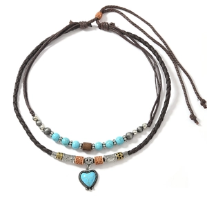 Detail of bohemian layered necklace with heart turquoise pendant and woven cord texture