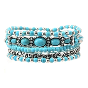 Detail of bohemian multilayer beaded bracelet set with turquoise stones and silver charms