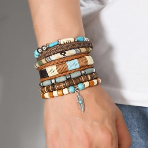 Detail of bohemian multilayer bracelet with turquoise beads and silver feather pendant