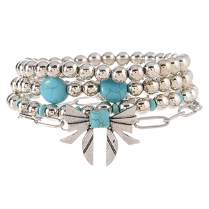 Close-up of vintage beaded bracelet set with turquoise stones and bow knot charm