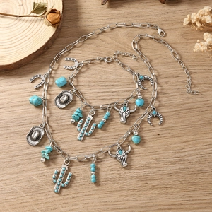 Detail of Western-style jewelry set with cactus, bull head, and horseshoe pendants