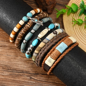 Detail view of Bohemian multilayer bracelets with turquoise beads and feather charm on stand