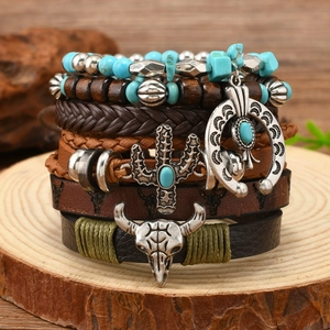 Close-up of Bohemian leather bracelets with turquoise beads and bull skull charms on wood