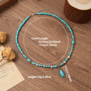 Detail of bohemian turquoise beaded necklace with droplet pendant on vintage wood backdrop