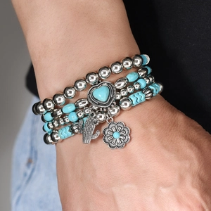 Detail of bohemian multilayer beaded bracelet set featuring blue turquoise and silver charms