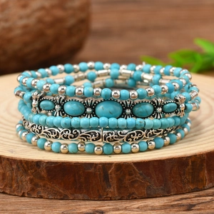Bohemian multi-layer turquoise bead bracelet set with silver charms on wood base