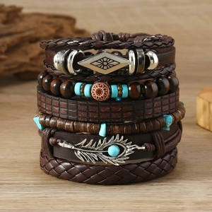 Detail of vintage bohemian leather bracelets with wooden beads and feather metal charms
