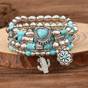 Detail of 5-piece bohemian beaded bracelet set with turquoise charms on wood