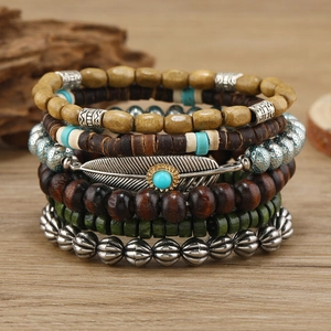 Bohemian multilayer wood bead and turquoise bracelet set featuring a metal feather charm