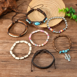 Detail of bohemian multilayer bracelet set with turquoise beads and cactus charm on wood