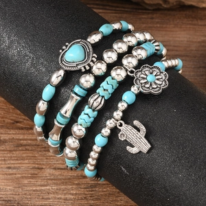 Detail of four-piece Bohemian beaded bracelet set with turquoise and silver charms
