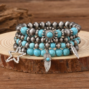 Detail of bohemian turquoise beaded bracelet set with sun, star and feather charms