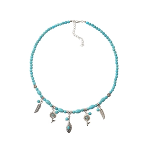 Collier bohème en perles de turquoise avec pendentifs ethniques vintage sur fond blanc