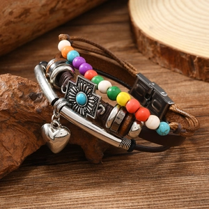 Detail of multi-layer leather bracelet with cross pendant and colorful beads on wood