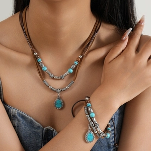 Detail of bohemian layered necklace and bracelet set with turquoise beads and silver charms