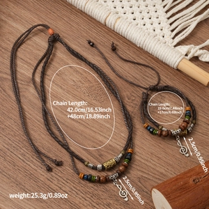 Detailed view of woven wolf tooth necklace with G-clef charm and vintage beads