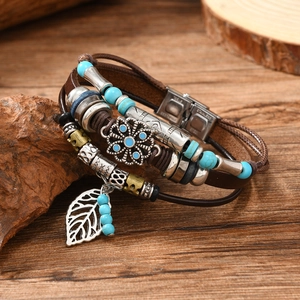 Detailed close-up of Bohemian leather bracelet with turquoise beads and leaf charms