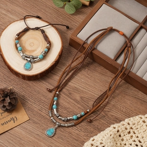 Close-up of bohemian multilayer necklace and bracelet with blue turquoise teardrop pendants
