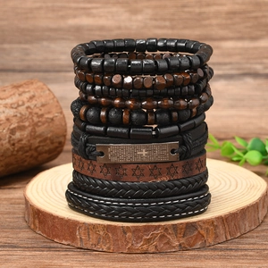Detail of multi-layer leather bracelets with wooden beads and engraved metal prayer plate