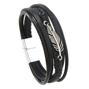 Detail of layered black leather bracelet with silver feather charm and magnetic clasp
