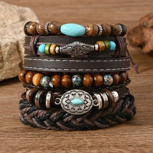 Detail of bohemian leather bracelets with turquoise stones and wooden beads on wood