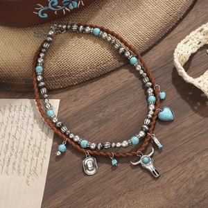 Detail van Western-ketting met turquoise hartje en hanger in de vorm van een stierenschedel