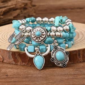Detailed close-up of Bohemian turquoise beaded bracelets with vintage silver charms