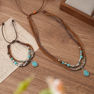 Detail shot of bohemian layered woven necklace and bracelet set with turquoise accents