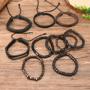 Detail of multi-layer men's bohemian leather and beaded bracelets set on wood background