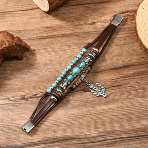 Detail of bohemian multilayer brown leather bracelet with cactus charm and turquoise beads