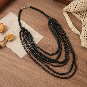 Detail of bohemian multi-layer beaded necklace with wooden beads and turquoise stones