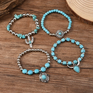 Detail of four bohemian turquoise beaded bracelets with cactus and sun charms