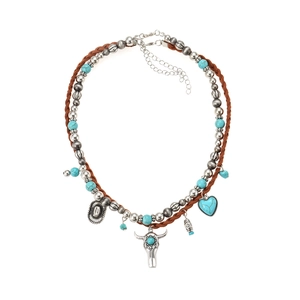 Detail van etnische ketting met turquoise kralen en hangers van stierenschedel en hart