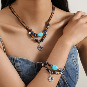 Detail of ethnic layered necklace with turquoise beads and retro floral pendants on model