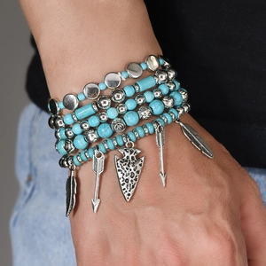 Detail of bohemian turquoise beaded multi-layer bracelets with silver feather charms
