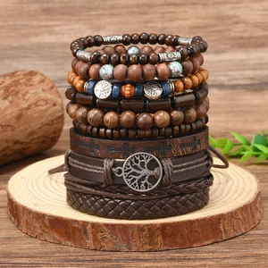 Detail of multi-layer bohemian bracelet set with tree of life and cross charms