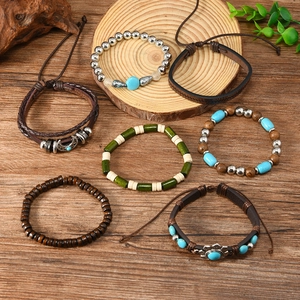 Detail view of 6-piece bohemian leather and wood bead bracelet set with ethnic charms