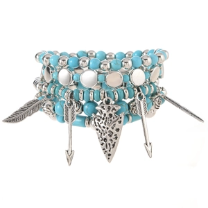 Detail of bohemian turquoise beads bracelet set with silver feather and arrow charms
