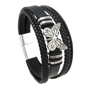 Detail of multi-layer black braided leather bracelet with silver butterfly metal charm