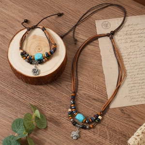 Close-up of bohemian woven jewelry set with turquoise beads and silver floral pendant
