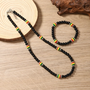 Detail of bohemian reggae style black beaded necklace and bracelet set on rustic wood